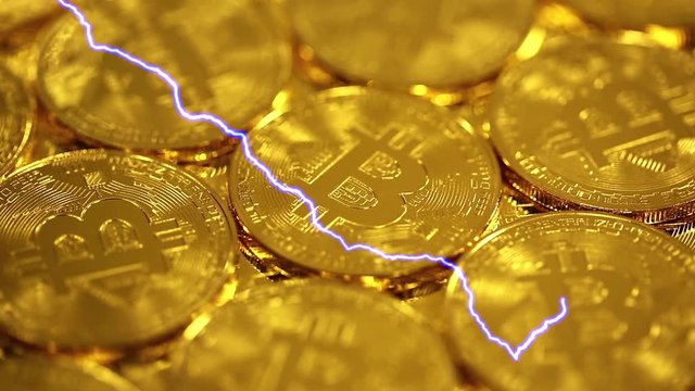 Blockchain technology, Bitcoins mining concept with lightning, macro shot of bitcoins. Cryptocurrency Bitcoin, BTC, coins rotates, power consumption concept