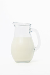 glass jug with milk, on white background