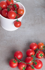 fresh red cherry tomatoes in plastic box on grey board for background