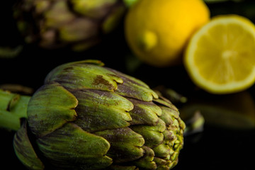 Artichokes posed and lemon on background