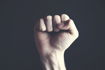 A clenched male fist is up in the air