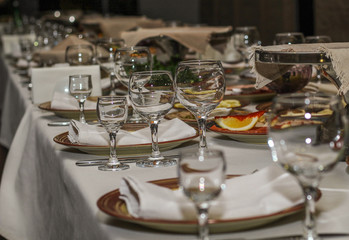 served table in restaurant, glasses and dishes with meat and fruit