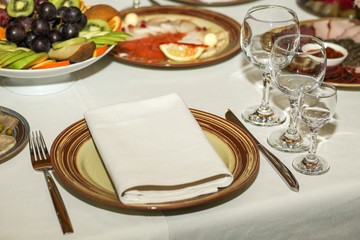 served table in restaurant, glasses, dishes with meat, cheese and fruit
