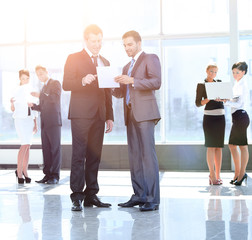 employees discuss working paper standing in the lobby of the off