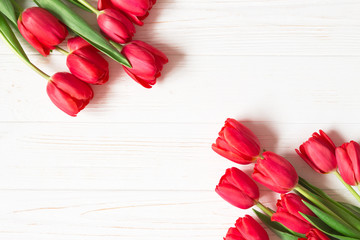 Bouquet of red tulips on white wooden background. Flat lay. Copy space.