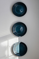 Three sunlit Blue pottery plates