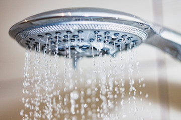 Fototapeta na wymiar shower head with drops of water falling down
