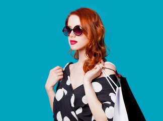 Redhead woman in sunglasses with shopping bags