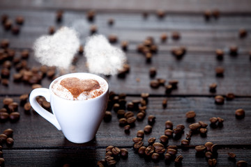 Cup of coffee with heart shape steam and beans