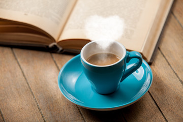 Cup of coffee with heart shape steam and open book