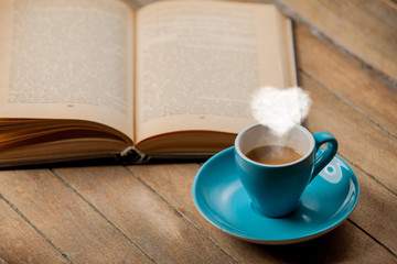 Cup of coffee with heart shape steam and open book