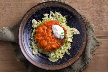 Salmon burgers nestled on a bed of coleslaw. Salmon fish cake. View from above, top