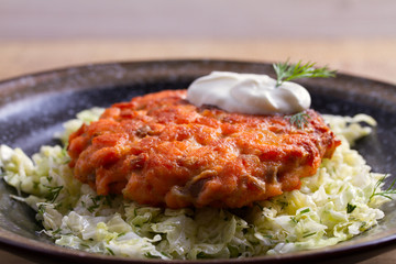 Salmon burgers nestled on a bed of coleslaw. Salmon fish cake