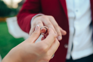 bride wears wedding ring to groom finger