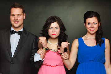 Wife and husband in handcuffs woman standing behind