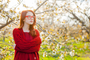 girl in red clothes in blossom cherry garden