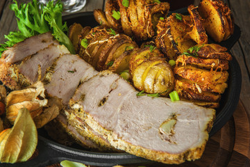 Slices of sliced sliced baked pork tenderloin with fried spiral potatoes.