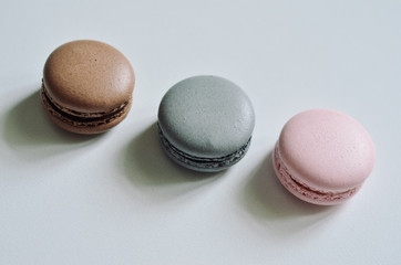 Pink, grey, brown macaroons white background, copyspace