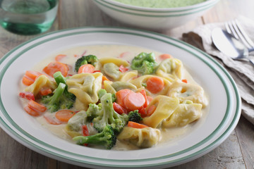 Tortellini with vegetables under cream sauce