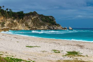 Fototapeta na wymiar Ideal Caribbean empty beach with azure sea and green rocks