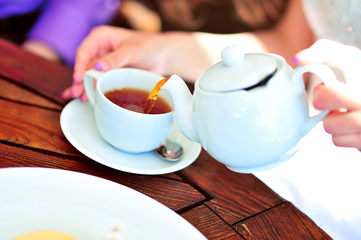 A newlywed couple drinking hot coffee or tea with sweet dessert in warm cozy cafe with wedding bouquet on the table. Atmoshere of happiness of new family and love tenderness