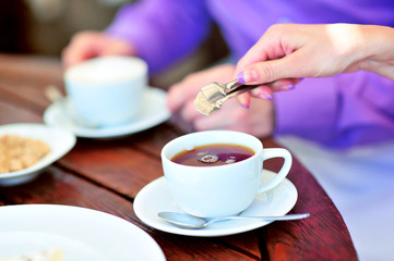 A newlywed couple drinking hot coffee or tea with sweet dessert in warm cozy cafe with wedding bouquet on the table. Atmoshere of happiness of new family and love tenderness