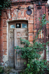 Old wooden door of red brick house