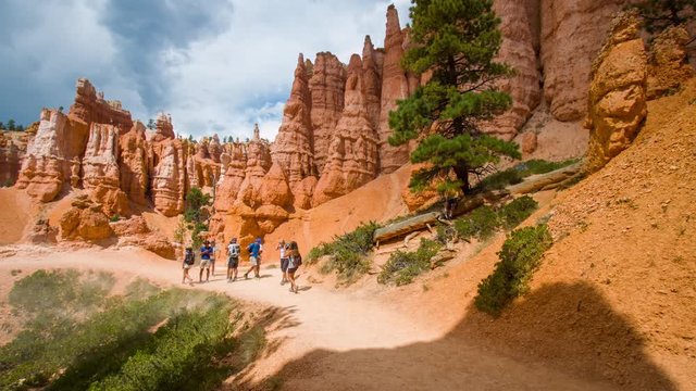Narrow footpath among yellow cliffs. Spectacular view at the cliffs. Tourists are walking along the trail. Bryce Canyon National Park. Utah. USA. 4K, 3840*2160, high bit rate, UHD