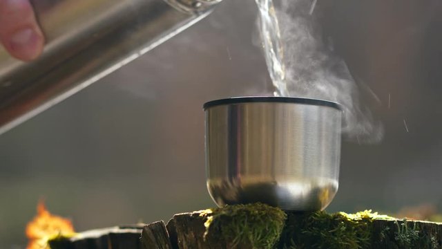 Man pouring tea in thermos flask