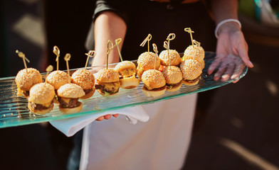 A waiter with a tray of snacks at a banquet or reception. Catering buffet at party