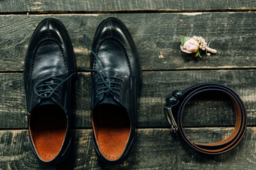 men's shoes blue, leather belt and buttonhole on a textured wooden background