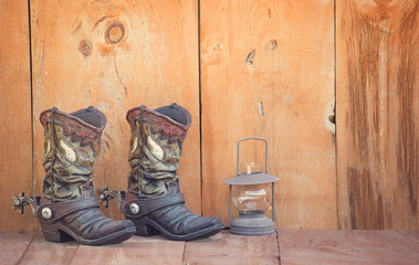 Rustic Cowboy boots with old fashioned kerosene lantern 