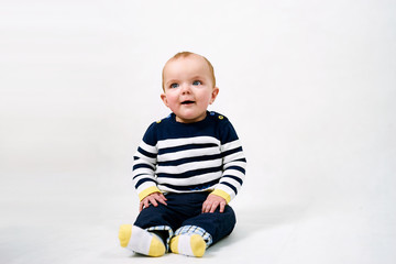 Cute smiling baby boy sitting on white background