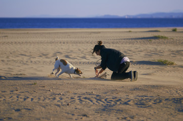 Woman playing with her dogs on a beach