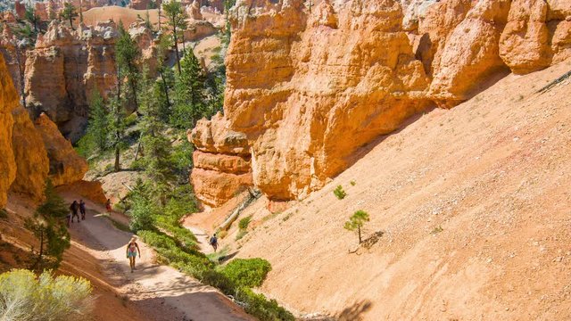 Tourists walking along the trail. Sunny day in the Bryce Canyon National Park. Nature video. Amazing mountain landscape. Spectacular view at the cliffs. Utah. USA. 4K, 3840*2160, high bit rate, UHD