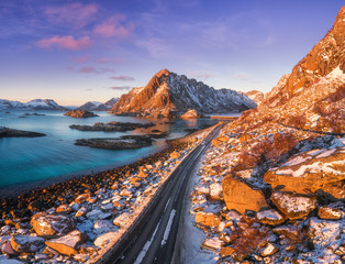 Aerial view of beautiful mountain road near the sea, mountains, purple sky at sunset in Lofoten...