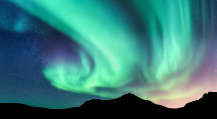 Aurore boréale et silhouette de montagnes. Îles Lofoten, Norvège. Aurore. Aurores boréales vertes et violettes. Ciel avec étoiles et lumières polaires. Paysage de nuit avec aurore, ciel bleu. Fond de nature