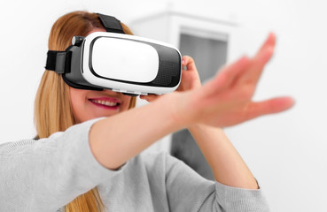 Beautiful young woman playing game in virtual reality glasses.