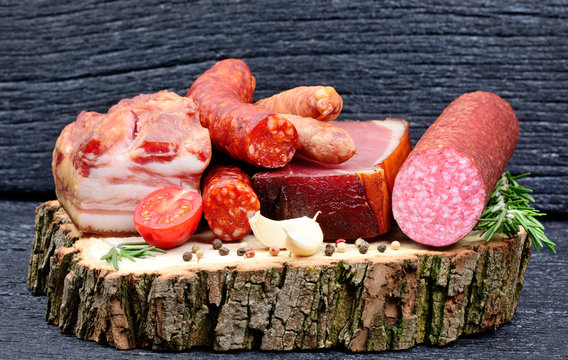 Smoked sausage with spices and garlic on a wooden board