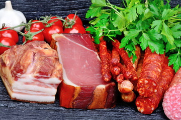 Sausages with cherry tomatoes, parsley and garlic on table