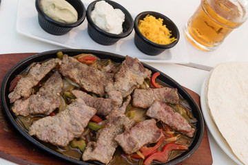 Delicious slices of roasted beef meat with red peppers served with various sauces and bread