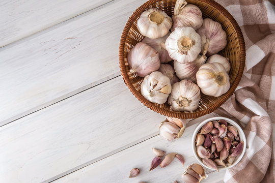  group of garlic on white wooden table board , top view or overhead shot with copy space