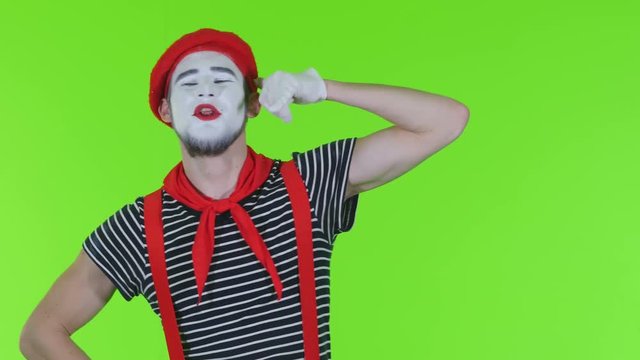 Mim man speaks by mobile on a green background
