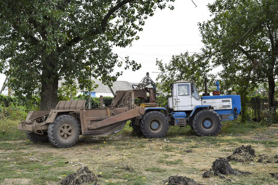 A large tractor with a grader on the trailer. Agricultural machinery
