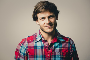 caucasian man wearing checkered shirt and trendy hairstyle