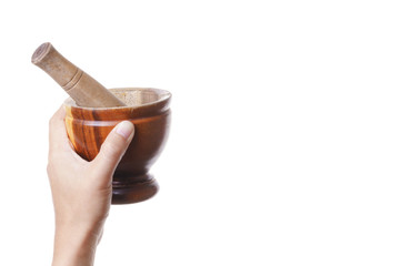 Hand holding wooden mortar and pestle made of wood