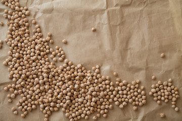 Fototapeta na wymiar Copy space: raw chickpea laying on a piece of craft paper