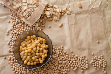 Copy space: boiled and raw chickpea, peanuts laying on a piece of craft paper