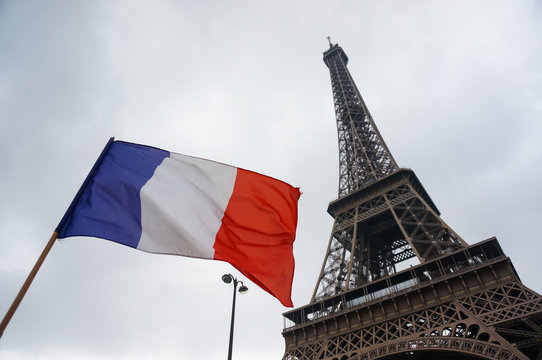 France flag with eiffel tower in backgrond with clear sky on April,11 2017 in Paris France.