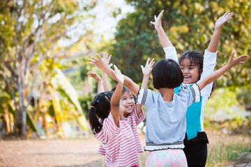 Asian children raise hands and playing together with fun in the park